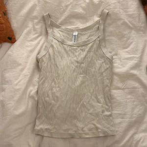 Beige ribbad linnetopp från Index - Säljer en stilren beige ribbad linnetopp från Index. Toppen har breda axelband 