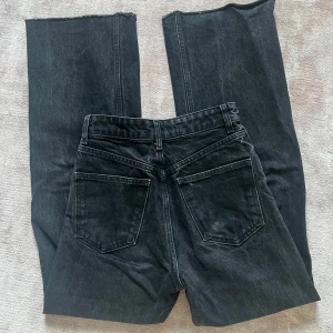 Zara Svarta wide jeans - Säljer ett par svarta jeans med hög midja och breda ben. Jeansen har råa, avklippta benslut för en edgy vibe och klassiska bakfickor. Tillverkade i kraftig denim som ger en snygg siluett. Perfekta för dig som gillar en avslappnad men trendig look.