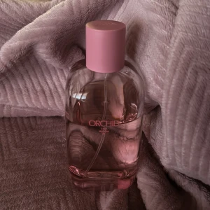 Zara Orchid parfym rosa flaska - Fräsch parfym från Zara i doften Orchid. Flaskan är genomskinlig med ljusrosa vätska och har ett stilrent, rundat utseende med en matt rosa kork. Perfekt för dig som gillar blommiga och feminina dofter.