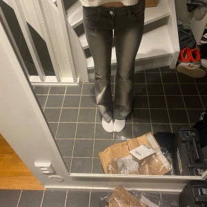 Grå bootcut jeans med slitningar - Snygga grå jeans med bootcut-modell och coola slitningar framtill och baktill. Klassisk femficksdesign och normal midja. Jeansen har en lätt utsvängd passform nertill och är tillverkade i ett mjukt denimtyg.