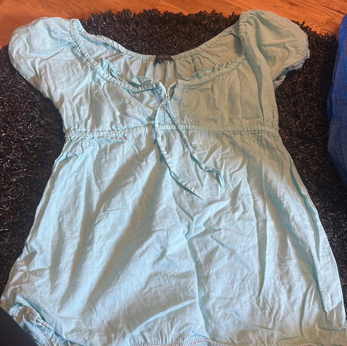 Ljusblå blus med knyt i halsen