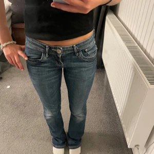 Blåa lågmidjade bootcut jeans - Säljer ett par blåa lågmidjade jeans från gross  med bootcut passform. Knappt använda🥰