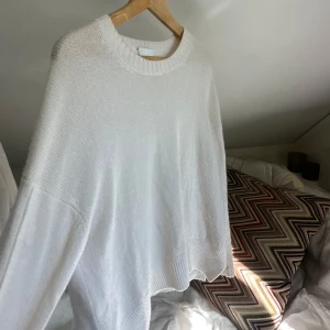 Kashmirtröja Allude - Supermjuk och oversized vit Kashmirtröja från Allude. Tröjan har rund halsringning, ribbade muddar och en avslappnad passform som ger en chill vibe. Perfekt att slänga på sig när du vill vara både bekväm och snygg.