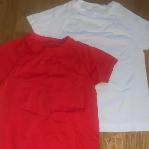 Röd och vit t-shirt i polyamid M - Två stilrena träningst-shirts i rött och vitt, båda med klassisk rund hals och korta ärmar. Bara testade. Satt för tajt på mig 