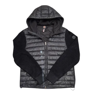 Colmar cardigan - Snygg svart hybridjacka från Colmar med quiltad framsida och huva. Jackan har stickade ärmar och baksida, dragkedja framtill och två fickor med dragkedja. Perfekt för lager-på-lager och streetstyle. Pris kan diskuteras den kan också passa M