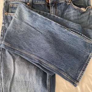 Blå raka jeans från Bershka - Klassiska blå jeans från Bershka i rak modell med fem fickor och snygga kontrastsömmar. Jeansen har normal passform och är tillverkade i bomull. Perfekta för en avslappnad och stilren look.