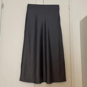 Grå långkjol  - (Ser lite mörkare ut på bilden) aldrig använd. Töjbart material precis vid midjan. 