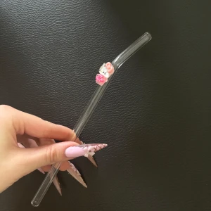 Söt glas-sugrör med Hello Kitty - Glas-sugrör med en gullig Hello Kitty-dekoration i rosa och vitt. Sugröret är transparent och har en böjd form upptill. Perfekt för dig som vill ha något extra sött till drycken!