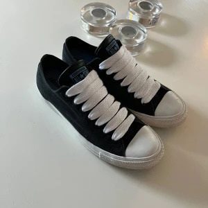 Converse All Star sneakers - Klassiska svarta Converse All Star sneakers med vit tå och breda vita snören. Ovandel i canvas och detaljer i gummi. Strl 42,5. 