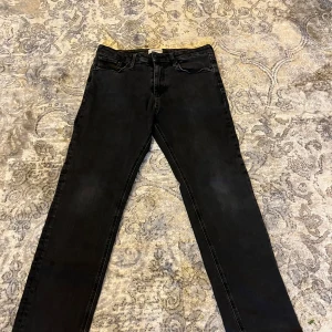 Svarta jeans regular/clark Jack & Jones 31/30 - Svarta skinny jeans från Jack & Jones i storlek 31/30. Klassisk femficksmodell med dragkedjegylf och smal passform. Snygga och enkla att matcha till olika outfits. Tillverkade i stretchig bomullsdenim för extra komfort. Det går bra att hämta upp dom om man har möjlighet