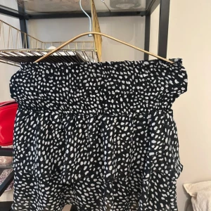 Svartvit prickig kjol från Chelsea - Supersöt svart klänning från Chelsea med vita prickar och smock upptill. Kjolen har en luftig och lätt känsla, perfekt för varma dagar. Passar även mig som är en storlek S!