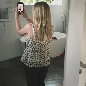 Beige prickig linnetopp med volanger - Säljer en beige linnetopp med svarta prickar och volangdetaljer. Toppen har tunna axelband och är i ett lätt, luftigt material som passar perfekt till varma dagar. Supersnygg att styla med jeans eller kjol! Den har en fin dragkedja på ena sidan och banden går att reglera💞(pris ej hugget i sten)