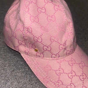 Rosa Keps - Säljer en rosa keps med klassiskt mönster i ljusrosa nyanser. Kepsen har justerbar rem baktill och är tillverkad i ett slitstarkt tyg. Perfekt accessoar för att lyfta din stil. För mer bilder/ Videos skriv!! Pris kan diskuteras!!