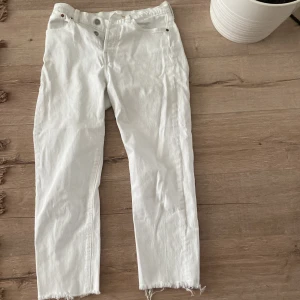 Vita jeansbyxor Levi's Wedgie Straight - Säljer ett par vita Levi's Wedgie Straight jeans med råa benslut. Klassisk femficksmodell med hög midja och raka ben. Perfekta för dig som gillar en tidlös och clean look.