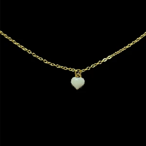 Halsband med vit hjärtberlock - Snyggt halsband med tunn guldfärgad kedja och en liten vit hjärtformad berlock. Perfekt accessoar för att lyfta din outfit med en söt detalj.