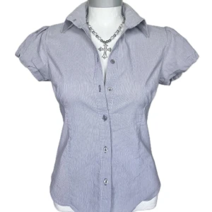 Kortärmad skjorta med puffärm - Snygg vit och grå skjorta med ränder och puffiga korta ärmar. Krage och knappar. Perfekt till jeans eller kjol! Storlek 40, kan även passa 38 🌸