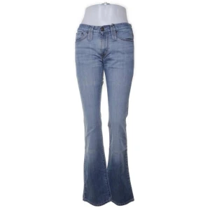 J.lindeberg Blå bootcut jeansbyxor - Snygga blå jeansbyxor med bootcut passform och klassisk femficksdesign. Jeansen har normalhög midja och subtila slitningar för en avslappnad look. Perfekta till vardags och lätta att matcha med olika toppar.