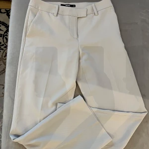 Ljus kostymbyxor från BikBok - Snygga ljusa kostymbyxor från BikBok. Byxorna är använda ett fåtal gånger. Petite version, jag är 161. Perfekta för en stilren look.