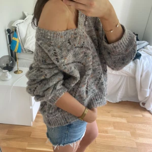 Grå stickad tröja med hålmönster - Mysig  stickad tröja med hålmönster. Tröjan har en oversized passform och långa ärmar, står ingen storlek men passar allt från s-l