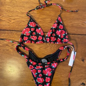 Blommig bikini Bright Swimwear - Säljer en snygg trekantsbikini från Bright. Trosan är oanvänd och har kvar sanitetsskyddet. Toppen är använd en gång. Säljer då den är lite liten, passar nog en S-M.