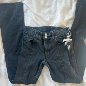 Lågmidjade svarta jeans - Lågmidjade jeans utan fickor. De har två knappar och en söm rakt ner på benet som syns på bilderna. Skulle säga att de är bootcut/straight. Det är i stretchiga material❤️  Mått Storlek: 164 Innerbenslängd: 70cm Midjemått: 32cm (mätt platt) Lårbrädd: 15cm (mätt platt) Höftbrädd: 36cm (mätt platt) Grenmått: 21cm  Längd längst ner på byxorna: 20cm (mätt platt)   #jeans #bootcutjeans #bootcut #straihtlegjeans #straight #lowwaist #lågmidjade #lågmidjadejeans #stockholmstyle #stockholm #stockholmstil #