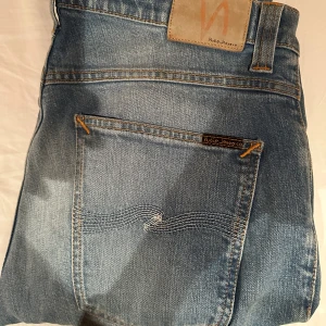 Nudie Jeans Grim Tim blå jeans - Säljer ett par Nudie Jeans Grim Tim i klassisk blå tvätt. Jeansen har raka ben 