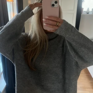 Grå stickad polotröja - Mysig grå stickad polotröja med lös passform och ribbad struktur. 