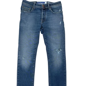 Jacob cohën Bard  - Brand: Jacob Cohën   Modell: Bard - a slim fit modell from Jacob Cohën but a more lose version from their slim fit collection!   Size:  W31   Recomended fit: W31   Condition: Very good, 8,5/10!   Details:  Light denim wash, with bronze hardware buttons. Has some distressed around the parts with makes them stand out in a cool way! SHOP NOW FASHIONELS.COM ! 
