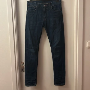 Mörkblå jeans från Nudie  - Säljer ett par mörkblå slim fit jeans från Nudie. Dom är i mycket bra skick, 9/10. Storlek w30 l32.