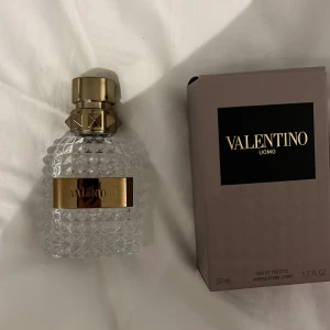 Valentino Uomo Eau de Toilette 50ml - Exklusiv herrparfym från Valentino, Uomo Eau de Toilette. Flaskan är genomskinlig med ett diamantmönster och har en lyxig guldfärgad kork och etikett. Kommer i originalkartong. Volym: 50 ml. En Tom Valentino flaska
