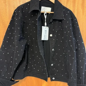 Svart jeansjacka med pärlor/nitar från YAS - Säljer en svart jeansjacka från YAS dekorerad med små pärlor/nitar över hela jackan. Aldrig använd. 