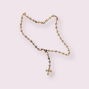 Guldfärgat halsband med kors - Säljer ett snyggt guldfärgat halsband med små kors längs hela kedjan och ett större kors som hänge. Perfekt för dig som gillar detaljer och vill sticka ut med dina accessoarer.
