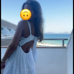 Vit sommarklänning med spets och öppen rygg - Säljer en superfin vit klänning med spetsdetaljer och öppen rygg med knytband. Klänningen är köpt i Spanien och är i storlek xs-s. Endast använd 1 gång🩷