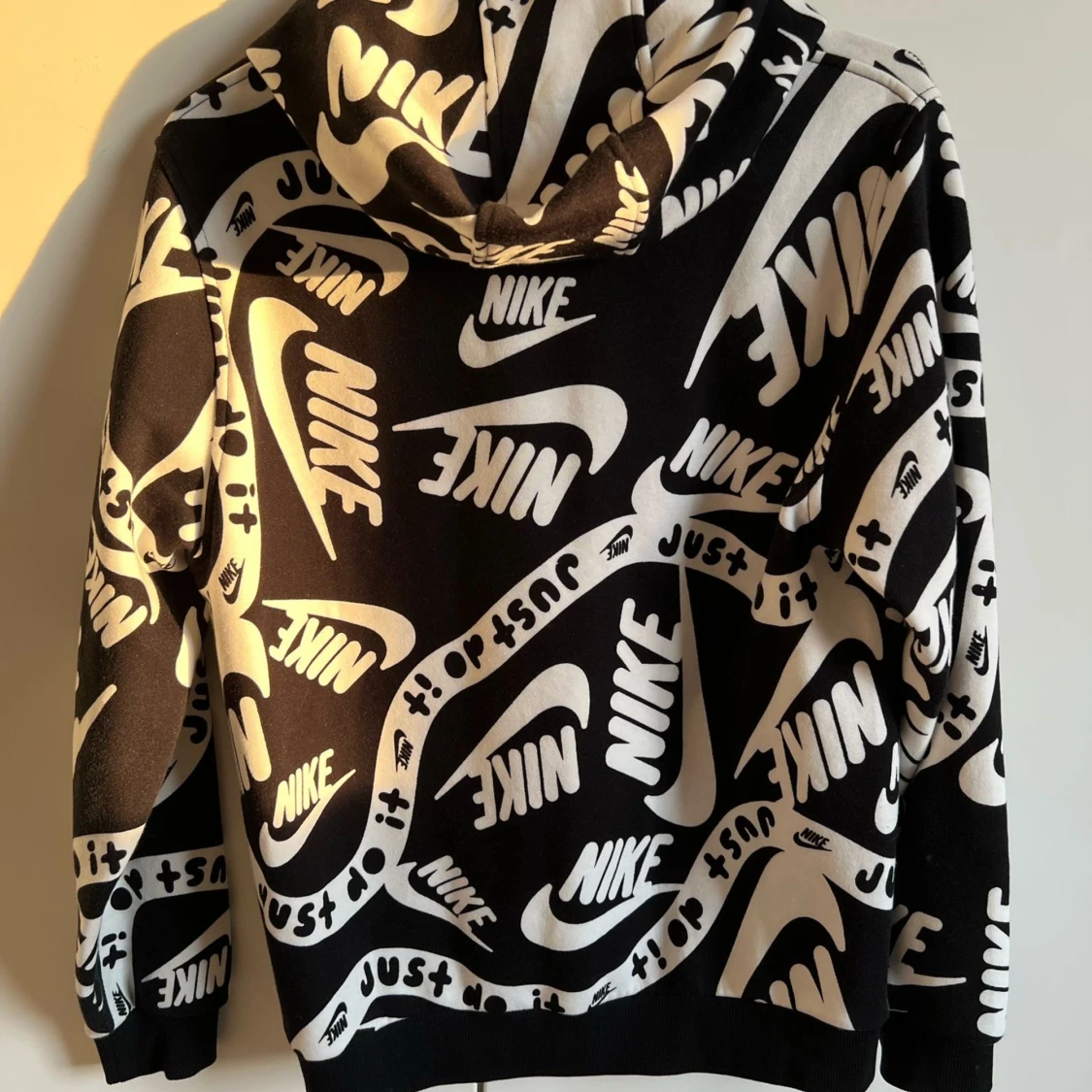 Svartvit hoodie från Nike med logga och text - 1