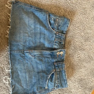 Jeanskjol från Stradivarius - Lågmidjad jeans kjol från Stravadius. Perfekt till sommaren. Säljer för att den tyvärr är för liten för mig. 