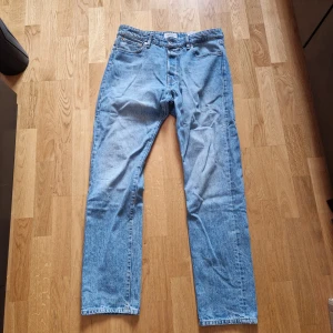 Blå jeans från Jack & Jones - Klassiska blå jeans från Jack & Jones med rak passform och fem fickor. Jeansen har normal midja och stängs med dragkedja och knapp. Perfekta till vardags för en avslappnad stil.