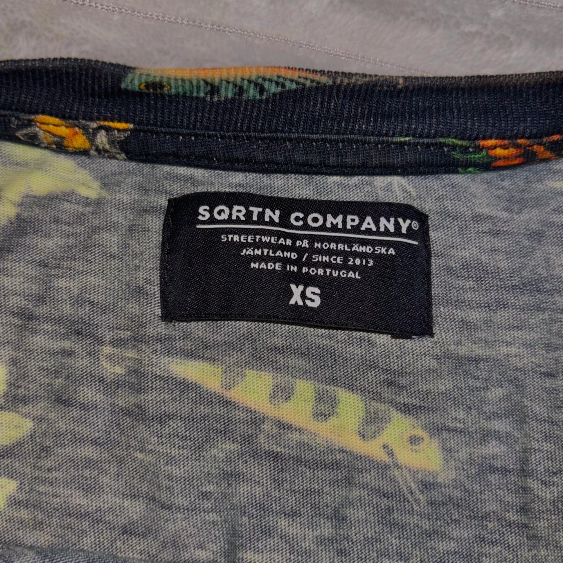 Svart t-shirt med blommigt och fiskmönster från Sqrtn Company - 2