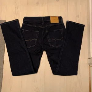 Mörkblå slim fit jeans Slim Fit / Tim - Säljer ett par mörkblå jeans i modellen Slim Fit / Tim. Byxorna har klassisk femficksdesign, raka ben och kontrastsömmar. Perfekta för dig som gillar en smalare passform. Storlek W29 L32.