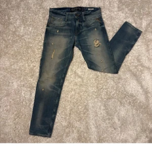 Blå Replay Anbass jeans med slitningar - Säljer ett par blå Replay Anbass jeans med snygga slitningar och detaljer. Stl W30/L30