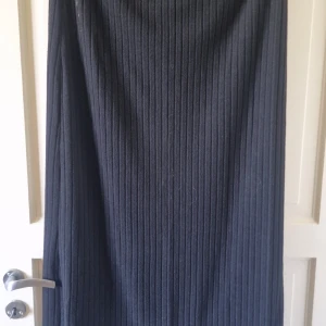 Svart ribbad klänning från SHEIN - Säljer en svart ribbad klänning från SHEIN i storlek XXL. Klänningen har en enkel och stilren design med vertikala ribbor som ger en snygg struktur. Perfekt att styla med sneakers eller boots.