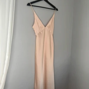 Champagnefärgad långklänning med smala axelband - Säljer en långklänning/balklänning i champagnefärg med smala axelband och djup v-ringning. Köpt på Billy J för 1450 inkl tull och frakt Kontakta för mer info😊 bud på 1000kr