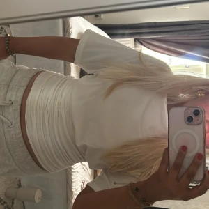 Vit midje tröja  - Säljer en stilren vit croppad t-shirt med korta ärmar. Perfekt för en avslappnad look. Passar bra till jeans eller shorts. Hör av dig vid intresse! Nypris 450kr