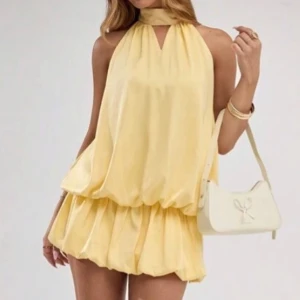 Klänning - Söt gul kortklänning med halterneck och knyt i nacken. Säljer pga råkade köpa i fel storlek. Klänningen har även inbyggda shorts!💞