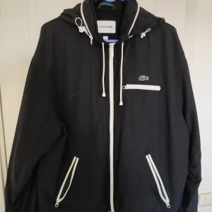 Lacoste Windbreaker - Lacoste windbreaker i storlek L, väldigt skön regnjacka som funkar i alla väder, använd fåtal gånger nypris:2000kr mitt pris:399kr priset är inte hugget i sten💸