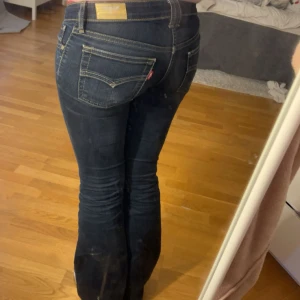 Lågmidjade levis jeans  - Jag säljer nu mina favorit jeans då dom tyvärr håller på att bli för små.  Det är lågmidjade mörkblåa bootcut levis jeans. Dom sitter perfekt vid midjan och är perfekt lågmidjade! Dem är i strl 27/32. Längst ner på byxorna finns det små slitningar och defekter som inte är något stort som märks ( se bild 5 ) men annars är dom i jättebra skick!  Midjemåttet är 37cm och innerbenslängden är 77cm🥰 Skriv om du har någon fråga eller fundering!😊 Priset är även förhandlingsbart vid snabb affär!
