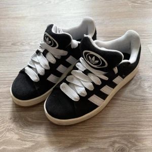 Adidas Campus 00 - Säljer mina Adidas campus 00 sneakers då dom inte kommer till användning längre. Använd ett fåtal gånger. Snörena är lite smutsiga men går säkert bort om man tvättar, har inte provat. Finns även ett par svara snören som är oanvända. Storlek 37 1/3