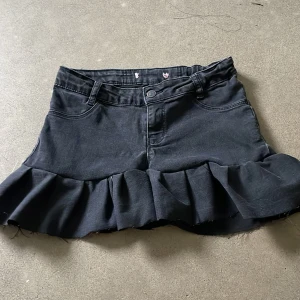 Svart jeanskjol med volang från Levi's - En svart jeanskjol som jag jag sytt själv. Hittade ingen lapp med storlek men skulle gissa xxs-xs, midijemåttet är 77cm.