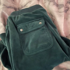 Mörkgröna mjukisbyxor från Juicy Couture - Mörkgröna mjukisbyxor från Juicy Couture med bakficka med knappar och broderad JC-logga. Byxorna är i storlek S tror jag men funkar även för M och Xs om man knyter dom i midjan.💗 säljer dom då jag inte använder längre och är använda cirka 4/5 gånger💗pris kan även diskuteras men lägger ut dom för 500 och köpte dom för 1199kr.