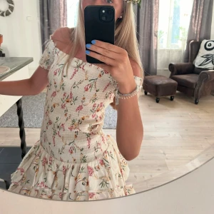 Blommig offshoulder klänning - Söt kortklänning med blommigt mönster Från H&M.  Offshoulder-modell med korta ärmar och volang nertill. Perfekt för sommaren. Storlek M, men passar s också. 
