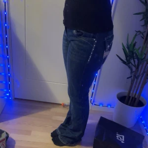 Blå bootcut jeans med dekorerade bakfickor - Säljer ett par super fina bootcut byxor från Bershka i storlek 38. Säljer för att byxorna är för långa har bara andvänt byxorna Max 5 månger men de har lite smuts på sig som går bort i tvätten. Jag är 162 cm lång så dessa skulle passa perfekt på dig som är 163-165 cm lång